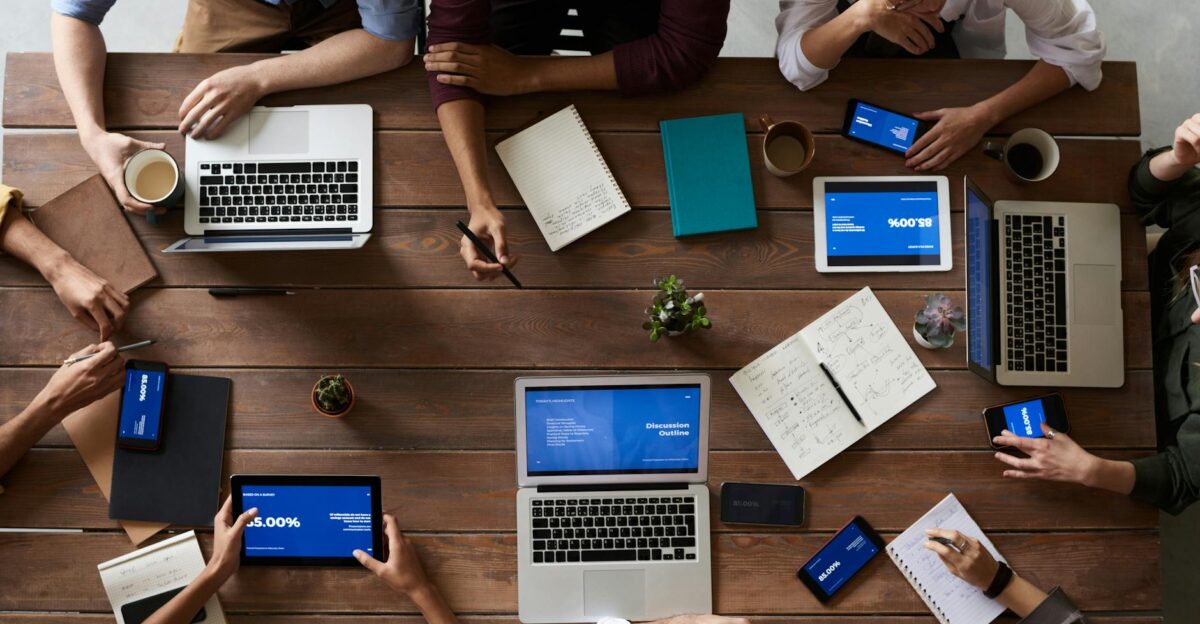 Overhead view of a diverse team in a business meeting using laptops and tablets