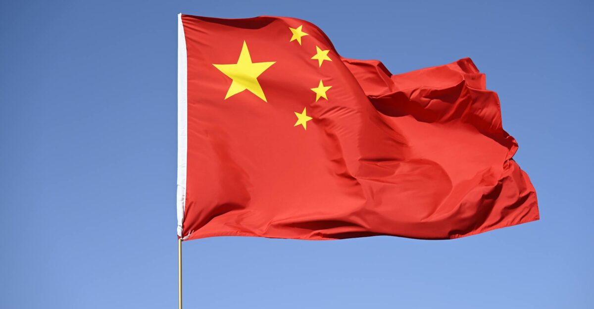 Chinese national flag flying high against a clear blue sky symbolizing unity and pride
