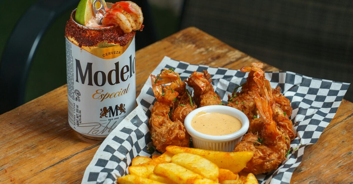 A delicious combo of crispy fried shrimp and fries paired with a Modelo beer