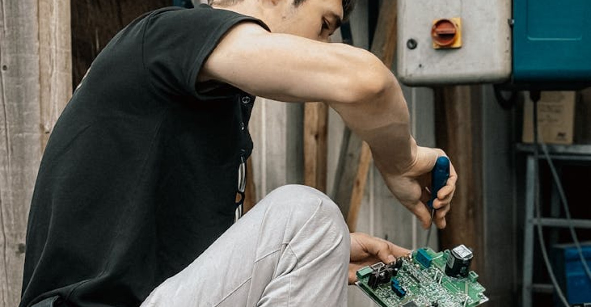Outdoor scene of a technician repairing electrical equipment in an industrial area