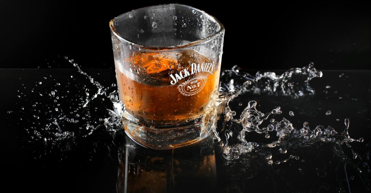 Dynamic shot of whiskey with ice and splash highlighting Jack Daniel s brand on glass