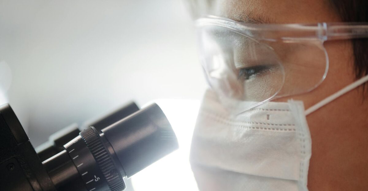 Close-up of a scientist wearing protective gear examining samples in a laboratory setting