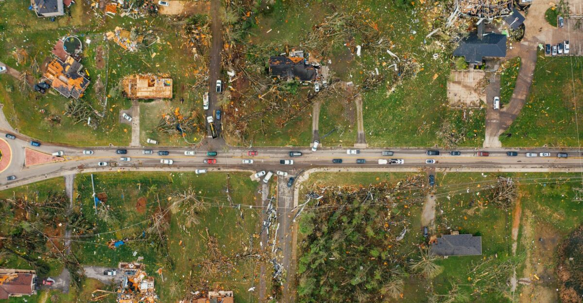 Aerial view of village houses ruined by wild storm near windthrown trees and electricity lines