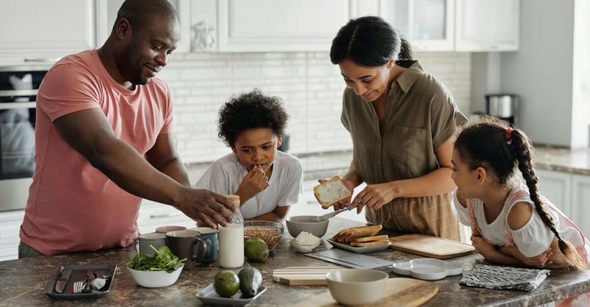 A joyful family enjoys preparing a healthy meal together in their modern kitchen