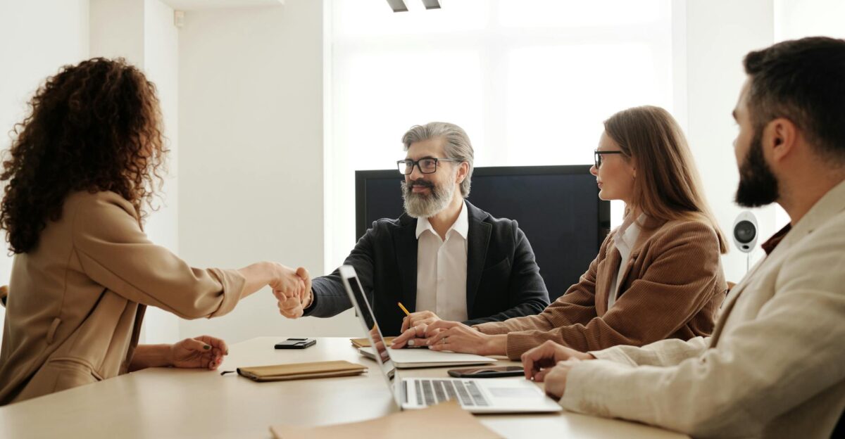 Colleagues in an office celebrating a successful negotiation with a handshake