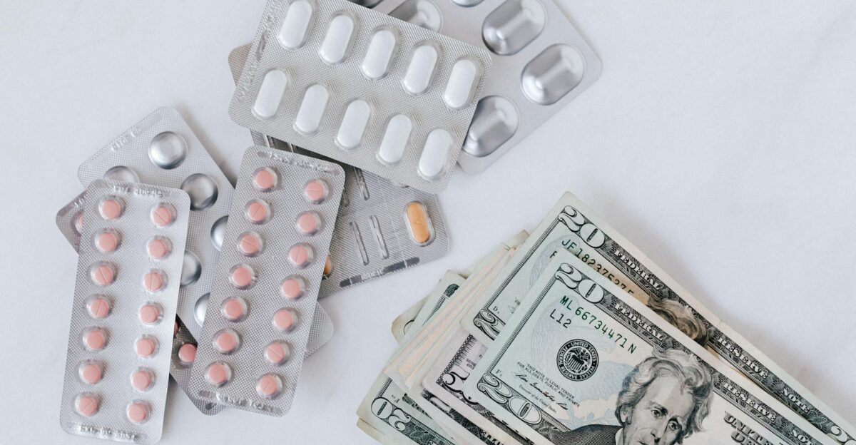 Top view of different blisters of medications and pills composed with heap of paper money