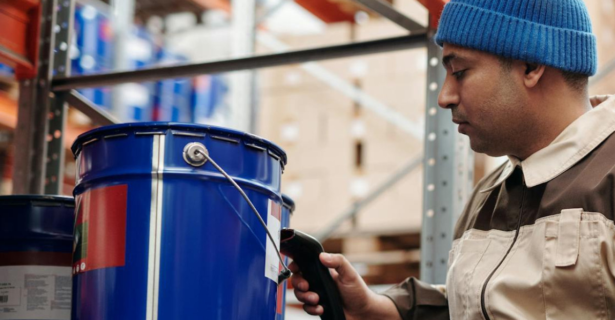 Warehouse employee scanning inventory using tablet and scanner in industrial storage area