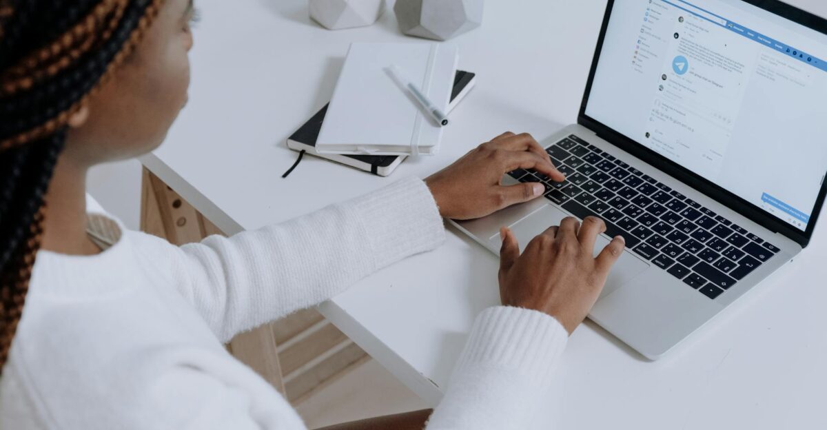 A woman engaging with social media on a laptop in a modern workspace