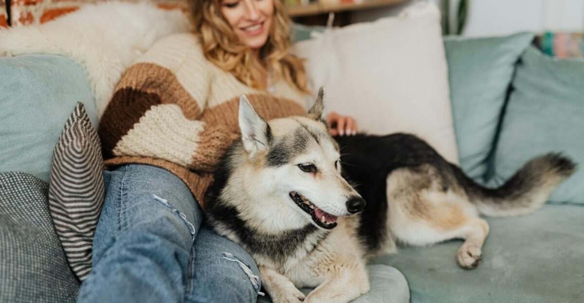 Woman relaxing with her dog on a comfortable sofa enjoying a cozy day at home
