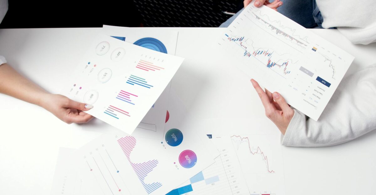 Hands holding business charts and graphs during a meeting showcasing financial analysis and investment strategy