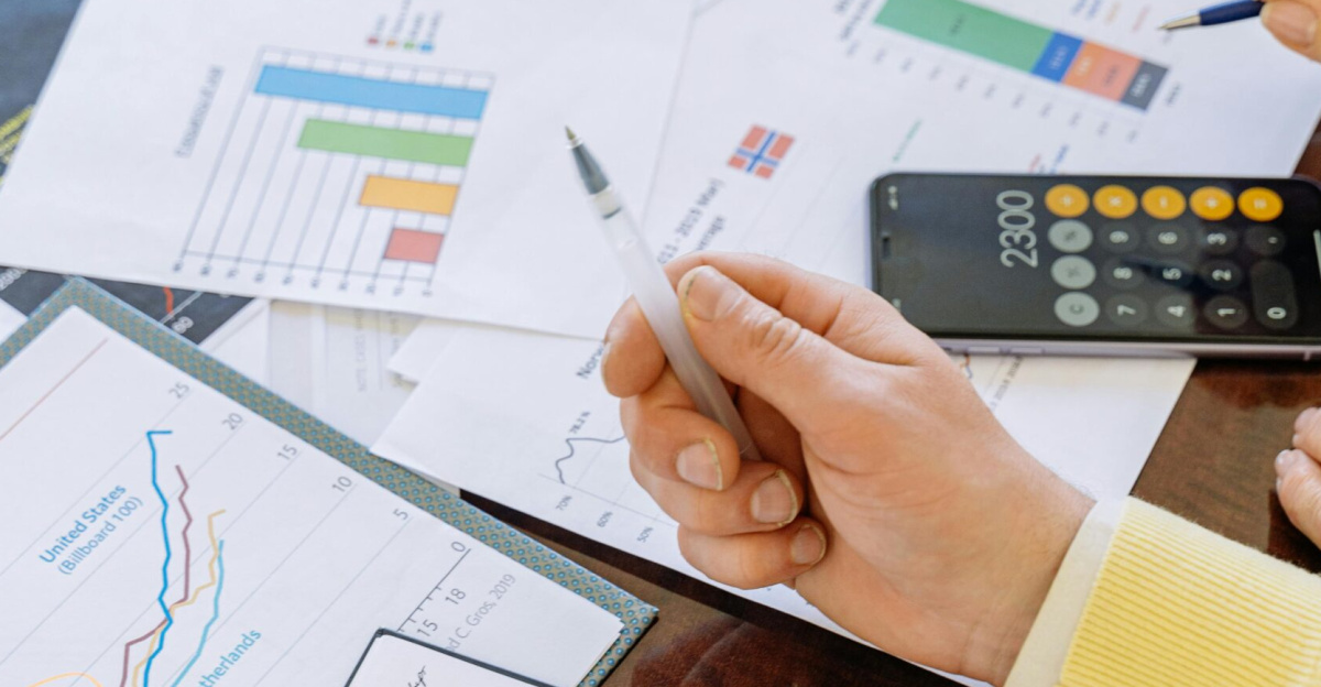 A close-up of businesspeople analyzing financial data and charts during a meeting.
