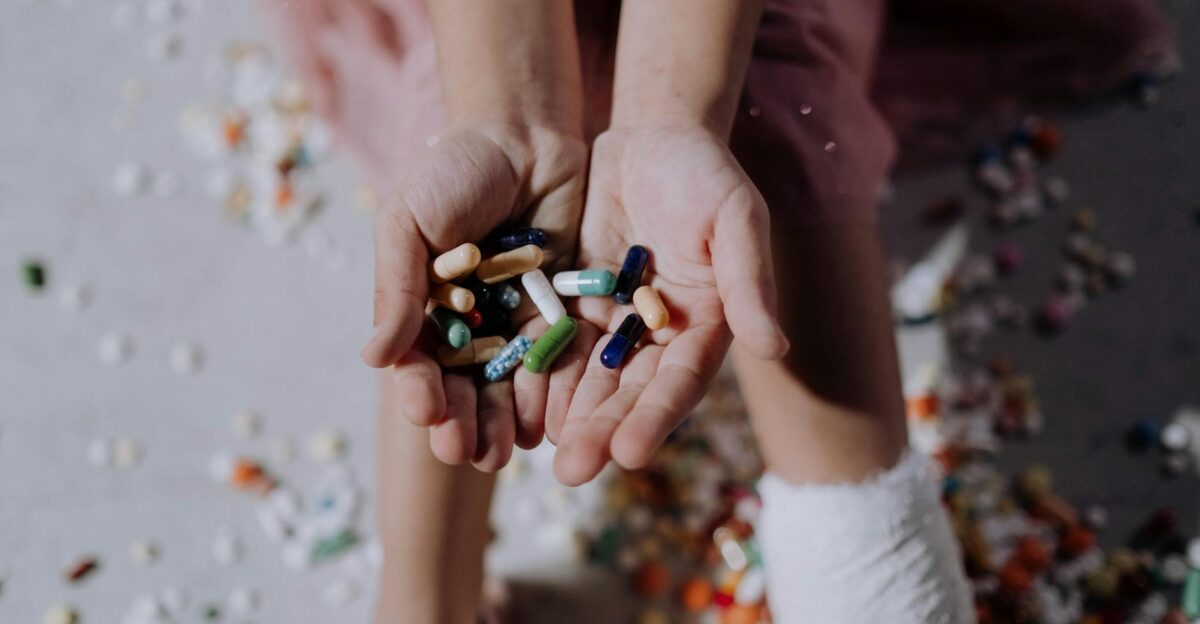 Close-up of a child holding pills with an injured leg in a cast symbolizing health and recovery