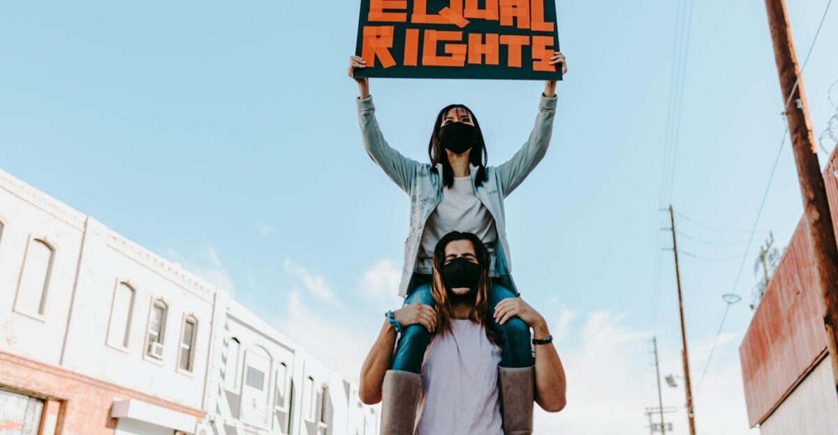Two people at a protest holding an Equal Rights sign advocating for social justice