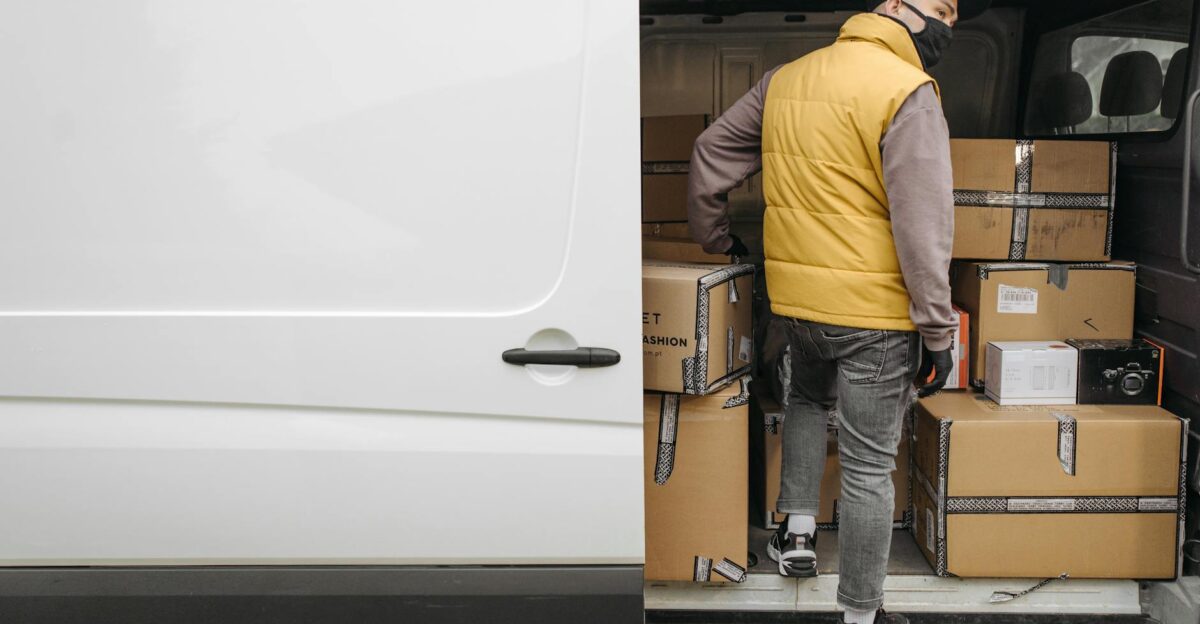 A deliveryman unloading packages from a van showcasing modern logistics
