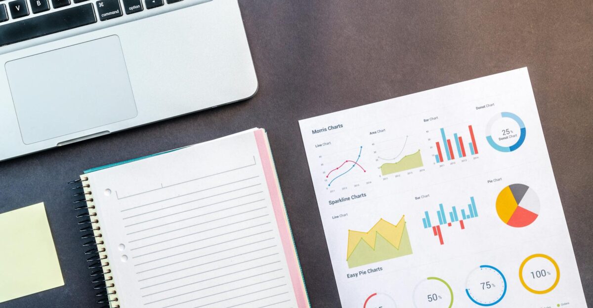 Top view of a laptop notebook and data charts on a table ideal for business and work themes