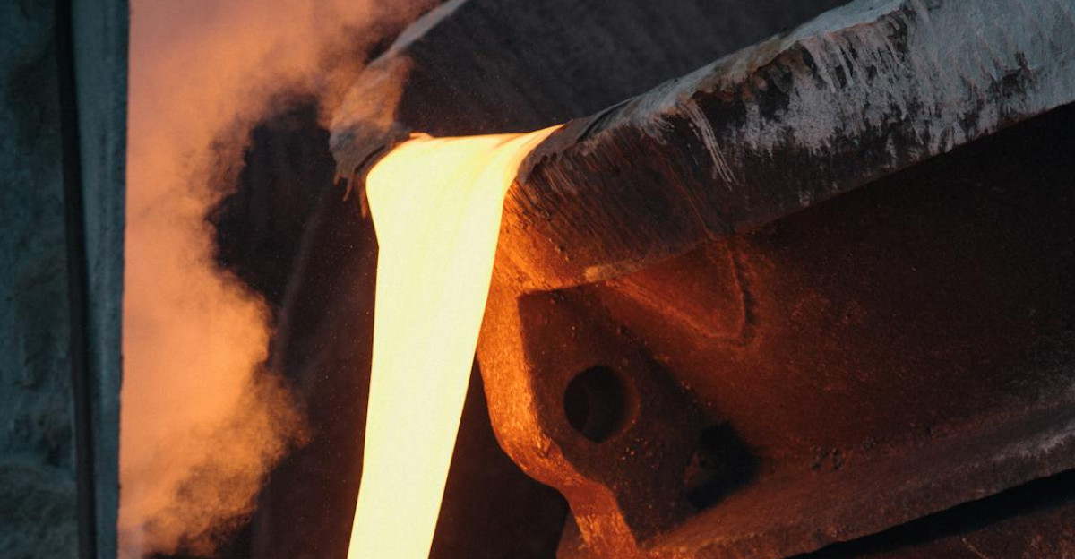 Molten metal pouring from ladle in industrial foundry capturing the intense heat and energy