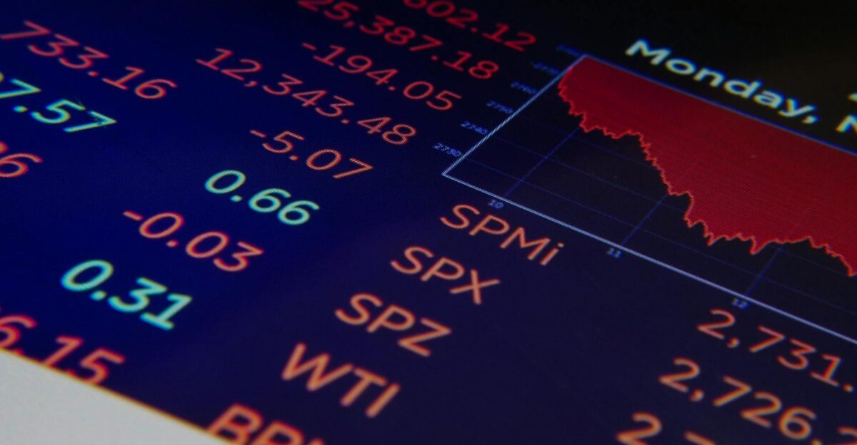 Close-up of a digital stock market graph showing falling trends and financial indices in red and green