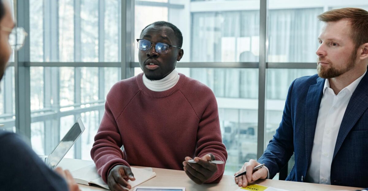 A group of professionals engaged in a business meeting discussing reports with digital tablets