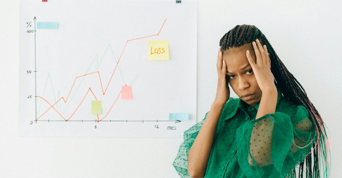 Businesswoman analyzing financial chart with loss noted expressing stress