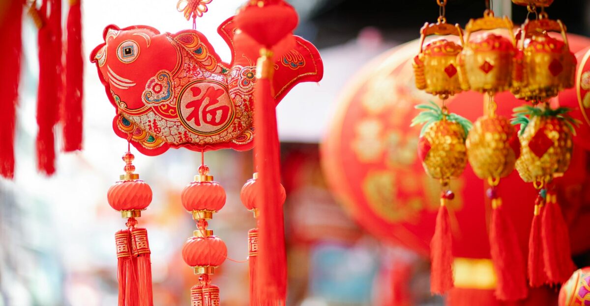 Colorful traditional Chinese lanterns hanging with fish shaped figures hanging on street for New Year