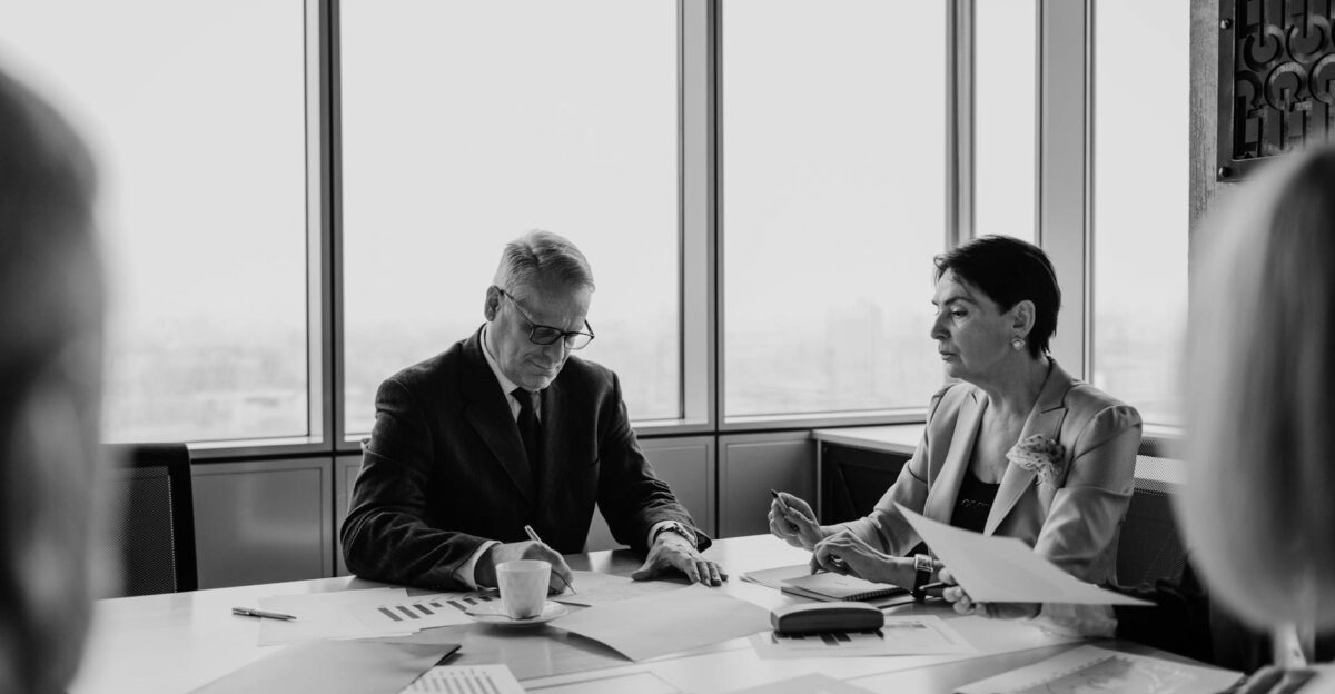 Black and white image of a business meeting with diverse professionals collaborating