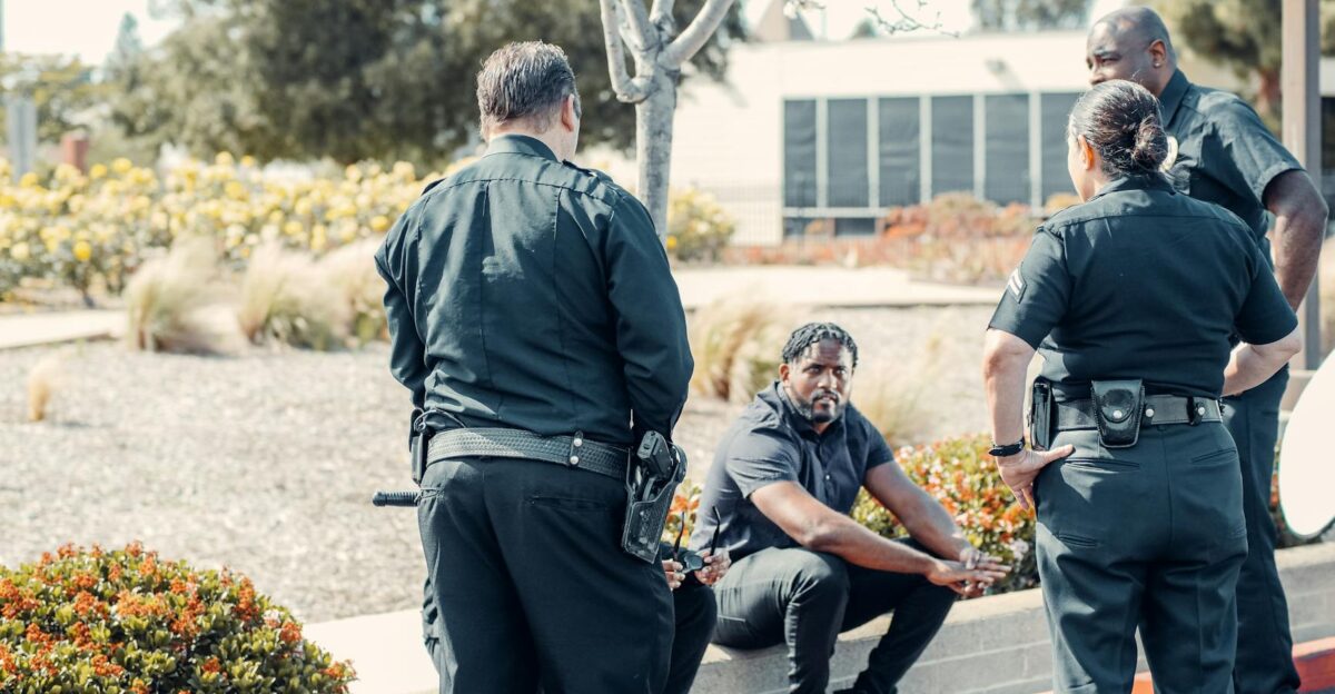 Law enforcement officers interacting with a person outdoors displaying cooperation and safety enforcement