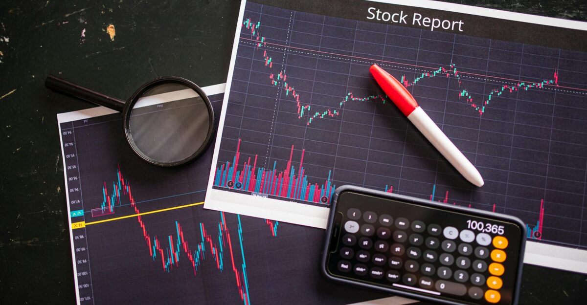 Stock report with charts calculator and magnifying glass for financial analysis