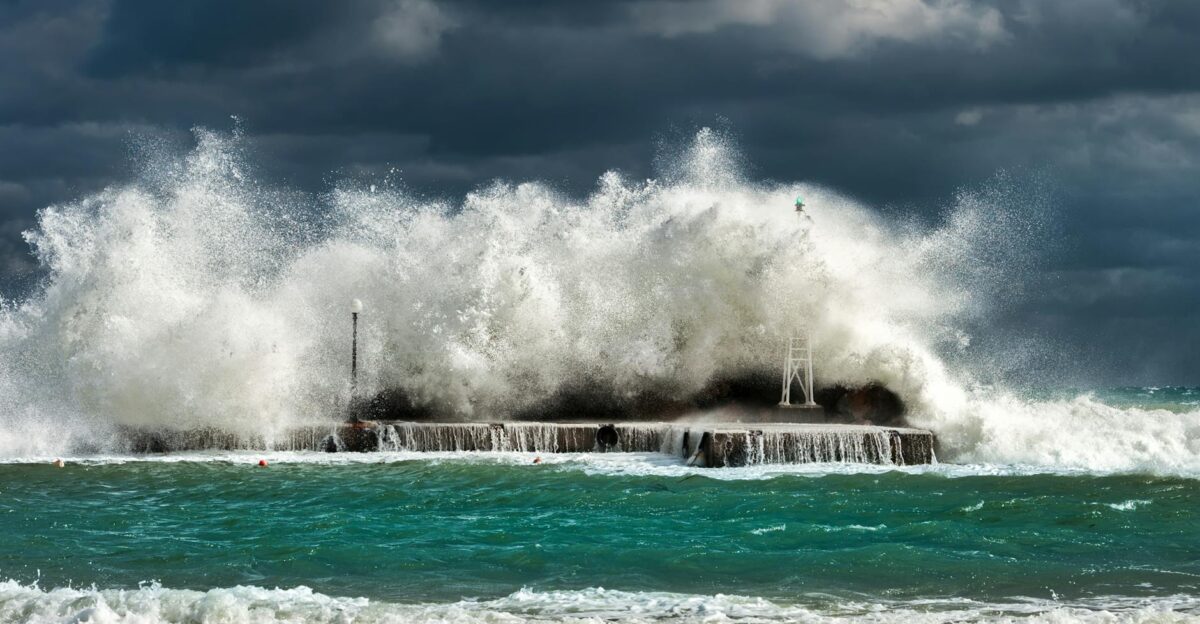 Dramatic ocean waves crashing against a concrete structure in Pantanassa capturing nature s raw power
