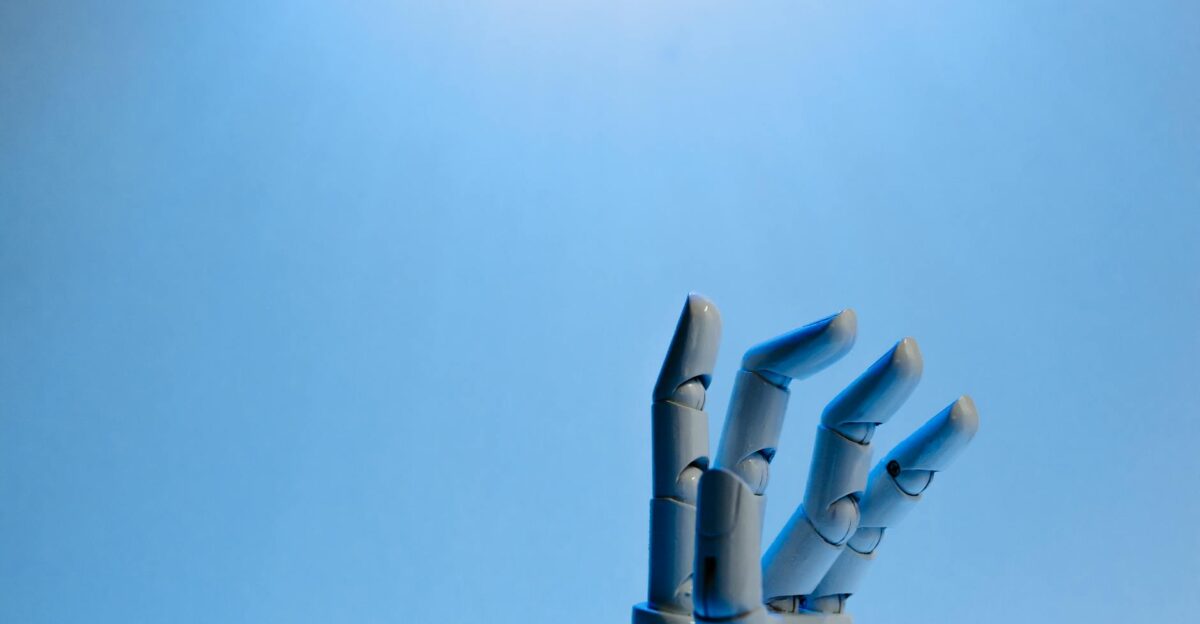 Robotic hand with articulated fingers reaching towards the sky on a blue background