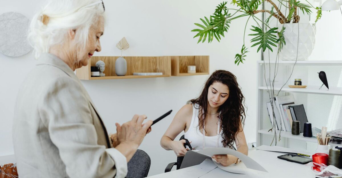 Two women collaborating in a modern design studio with fabrics and office decor