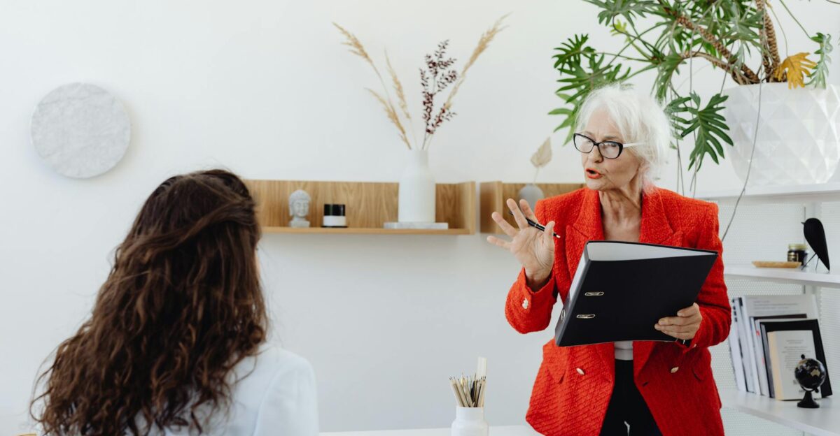 Elderly businesswoman presenting in office to a colleague indoors