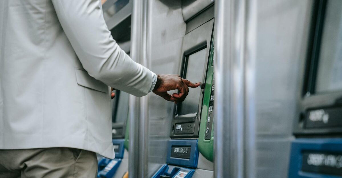 Side view of an adult using a self-service ticket machine indoors