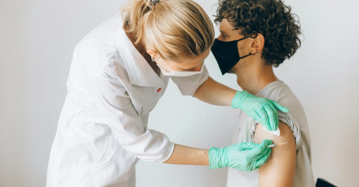 A healthcare worker gives a vaccine shot to a patient wearing a mask highlighting medical safety and health precautions