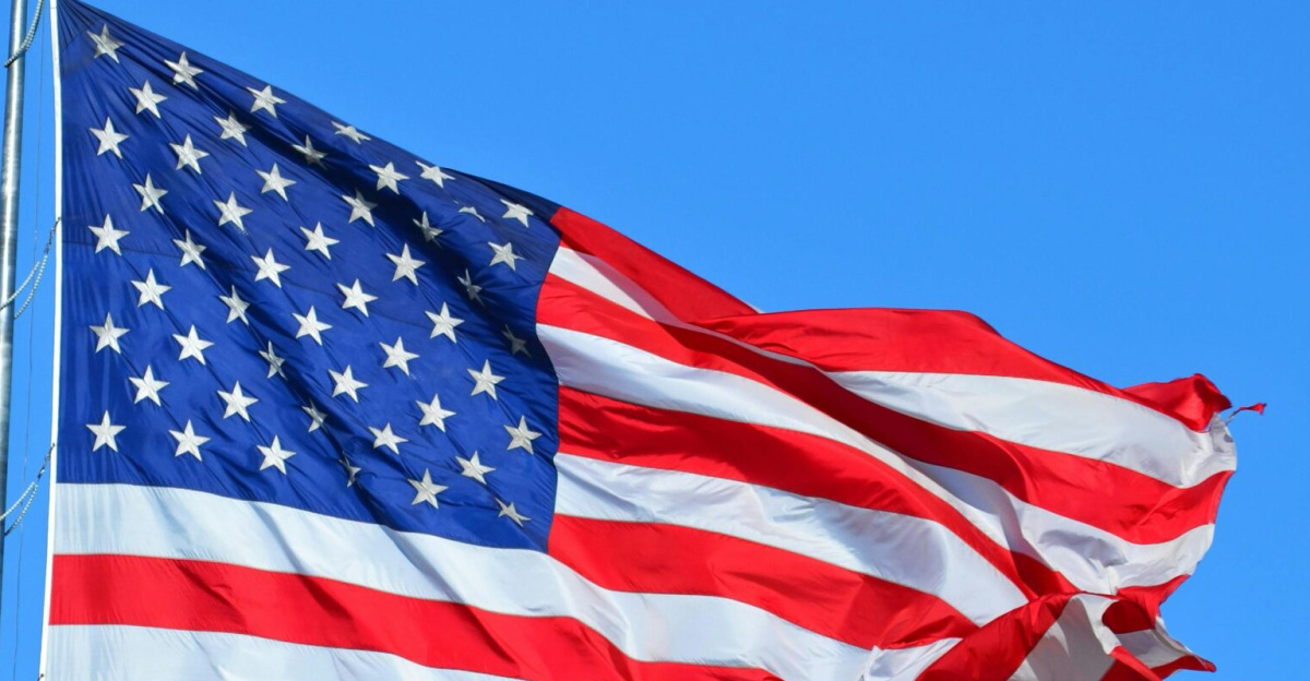 Majestic American flag waving against a bright blue sky, symbolizing freedom and patriotism.