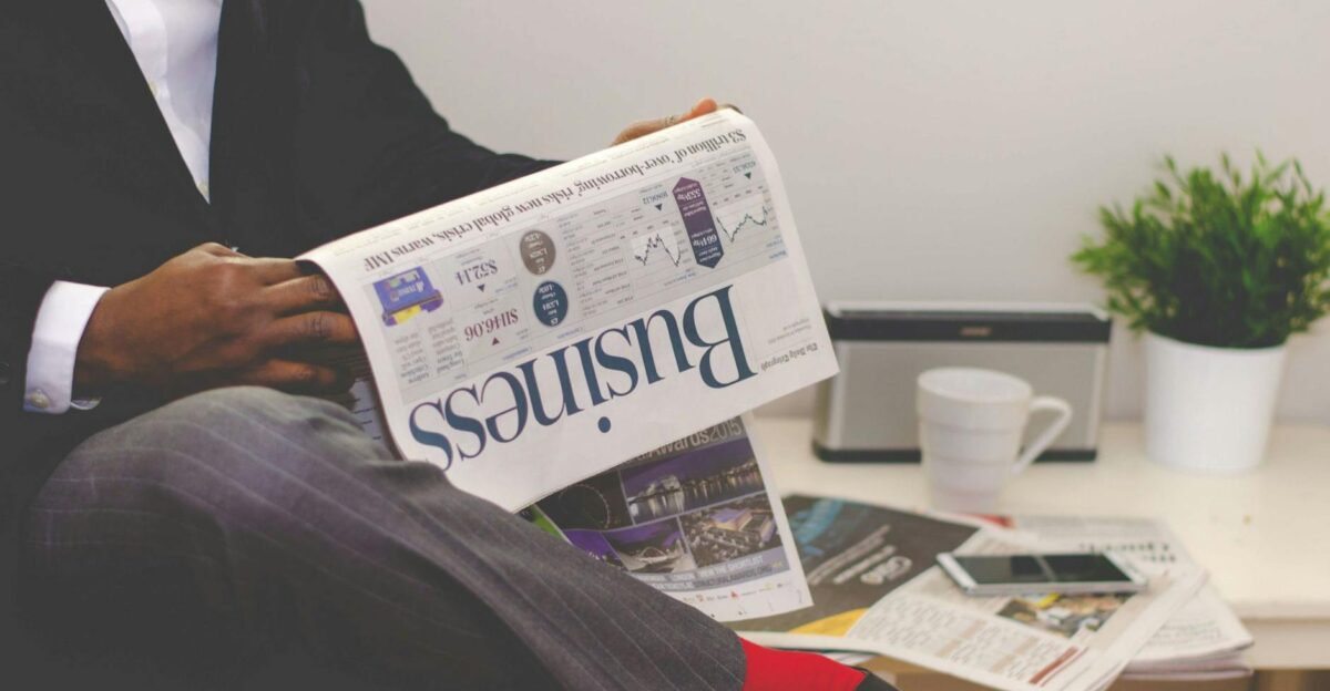 Businessman reading a financial newspaper at a desk highlighting finance and commerce theme