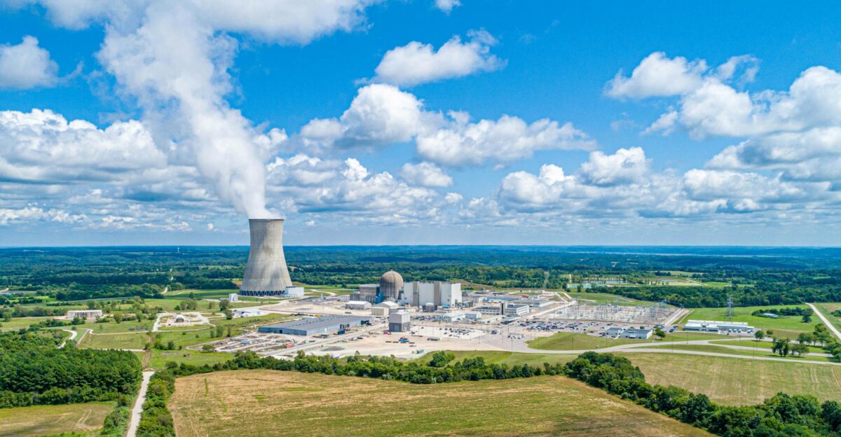 Aerial view of Callaway Nuclear Plant with cooling tower amidst lush landscape under a blue sky