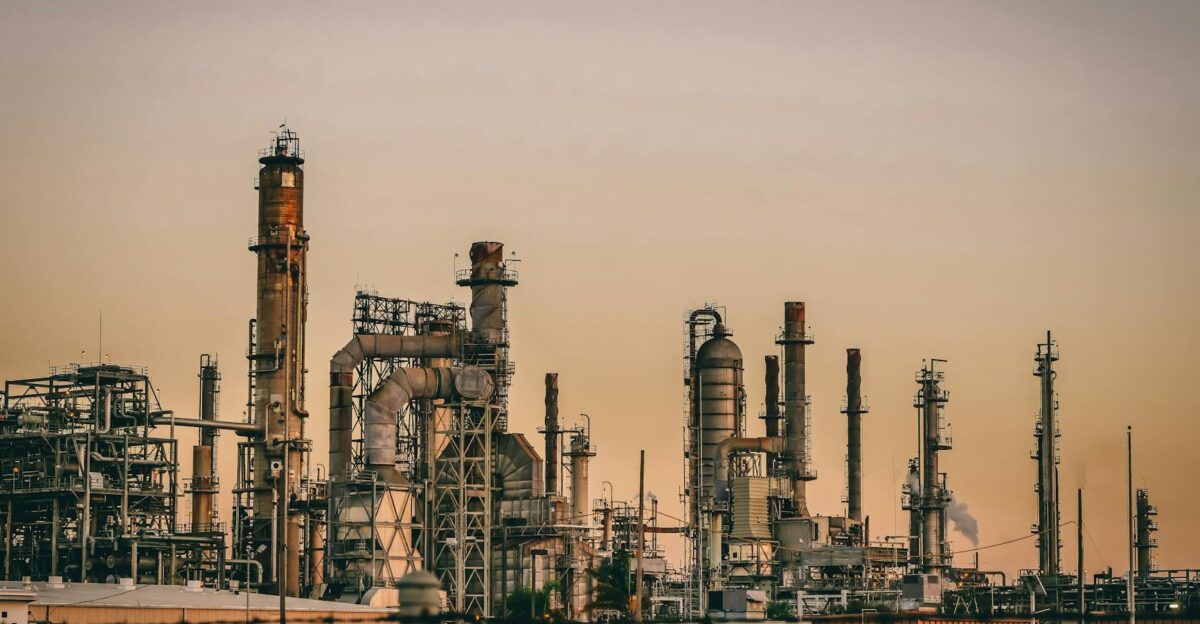 A large industrial power plant silhouetted against the warm hues of a sunset