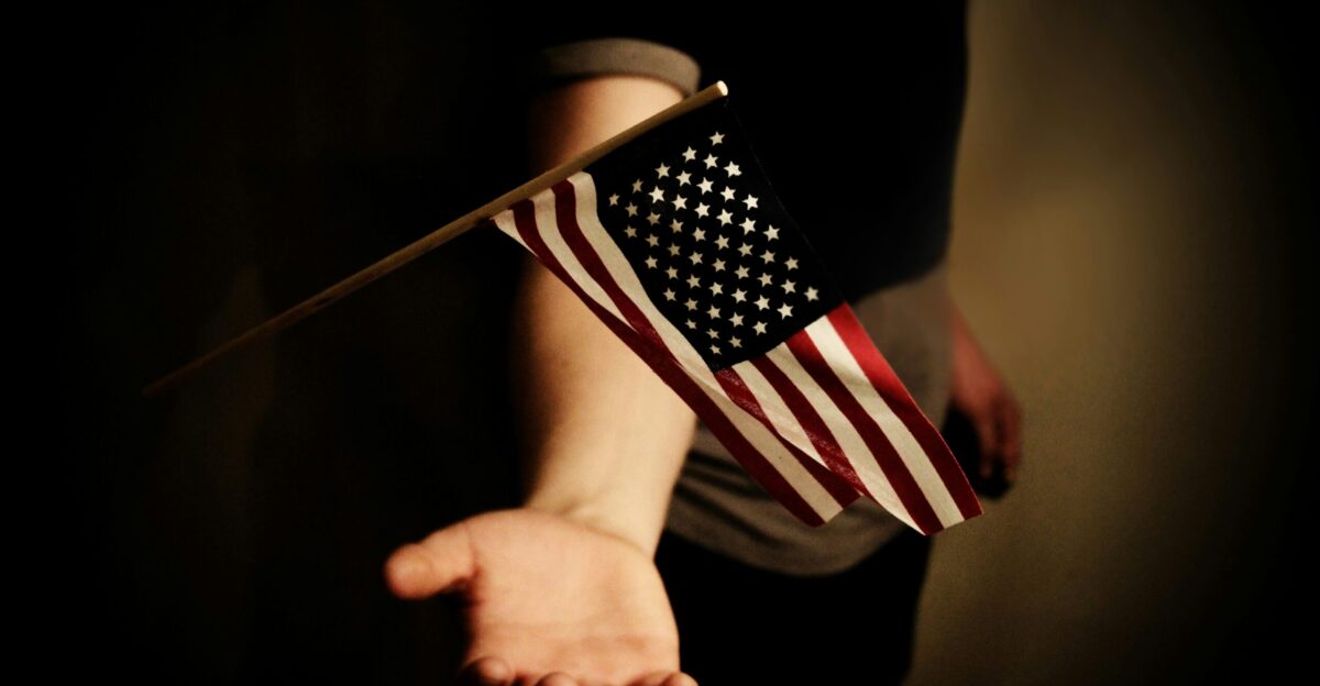 person with open palms below USA flaglet