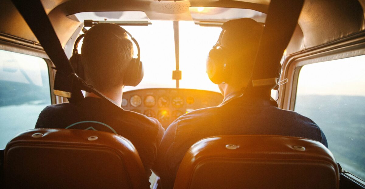 two men piloting plane during daytime