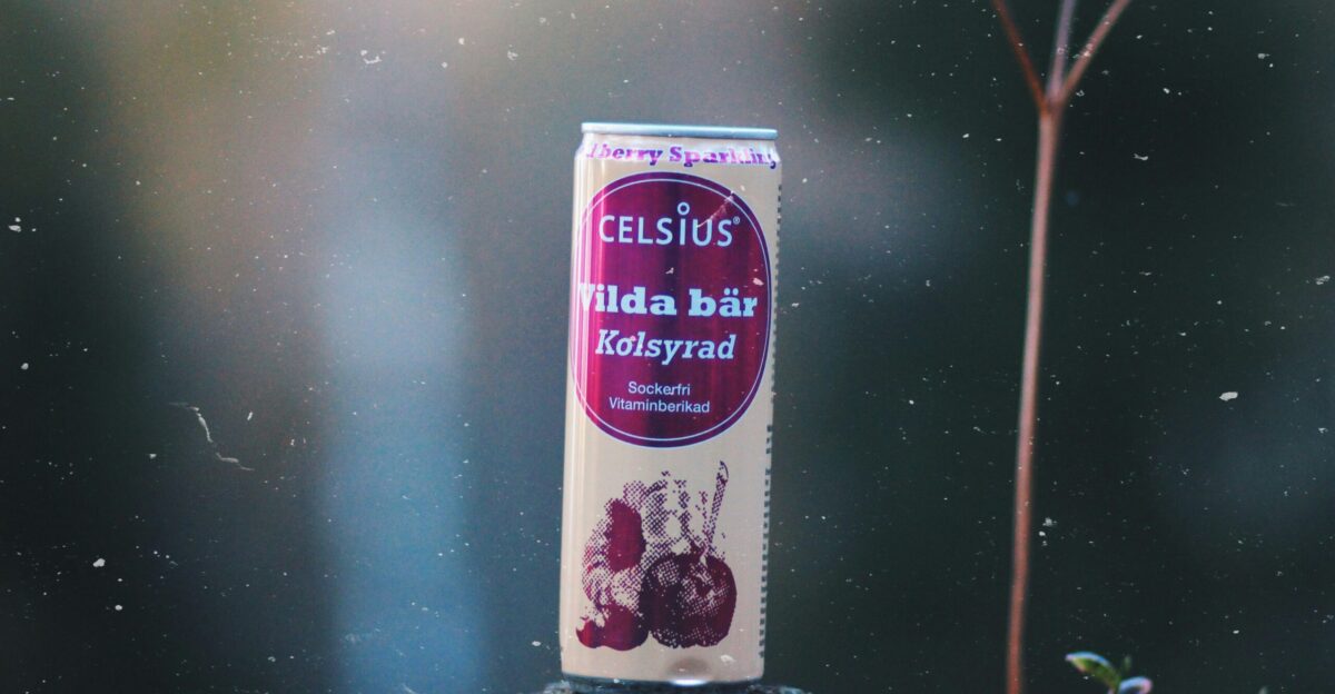 selective focus photography of Celsius Vilda Bar Kolsyrad can on black tree log