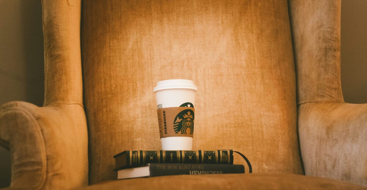 white Starbuck plastic cup on brown fabric armchair