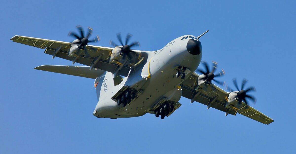 grey military cargo plane on flight under clear blue sky