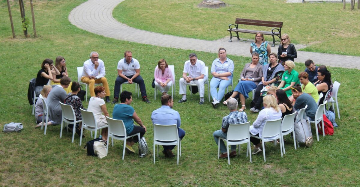 circle of people sitting on chair on grass fiedl