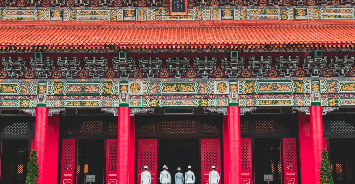 a group of people standing in front of a red building