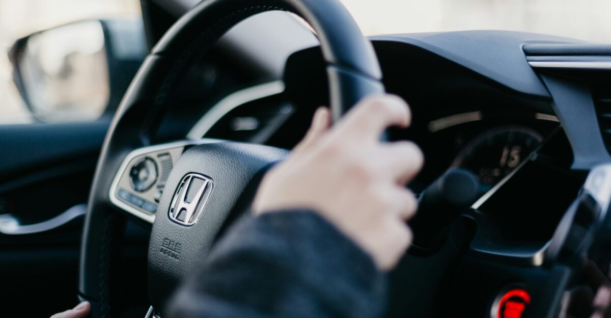 shallow focus photo of person driving Honda car