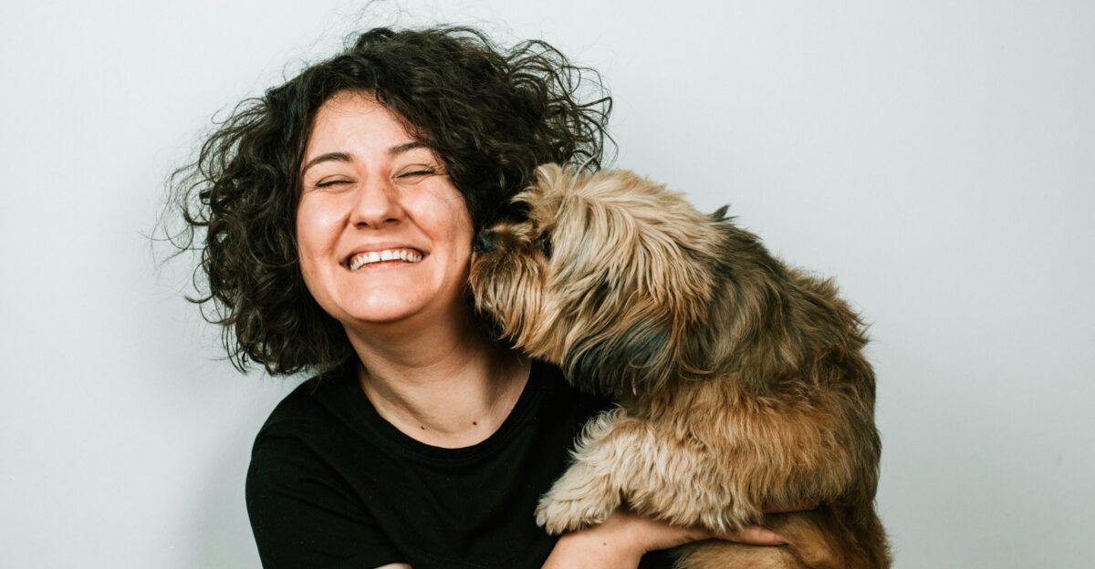 dog kissing woman in black crew-neck shirt