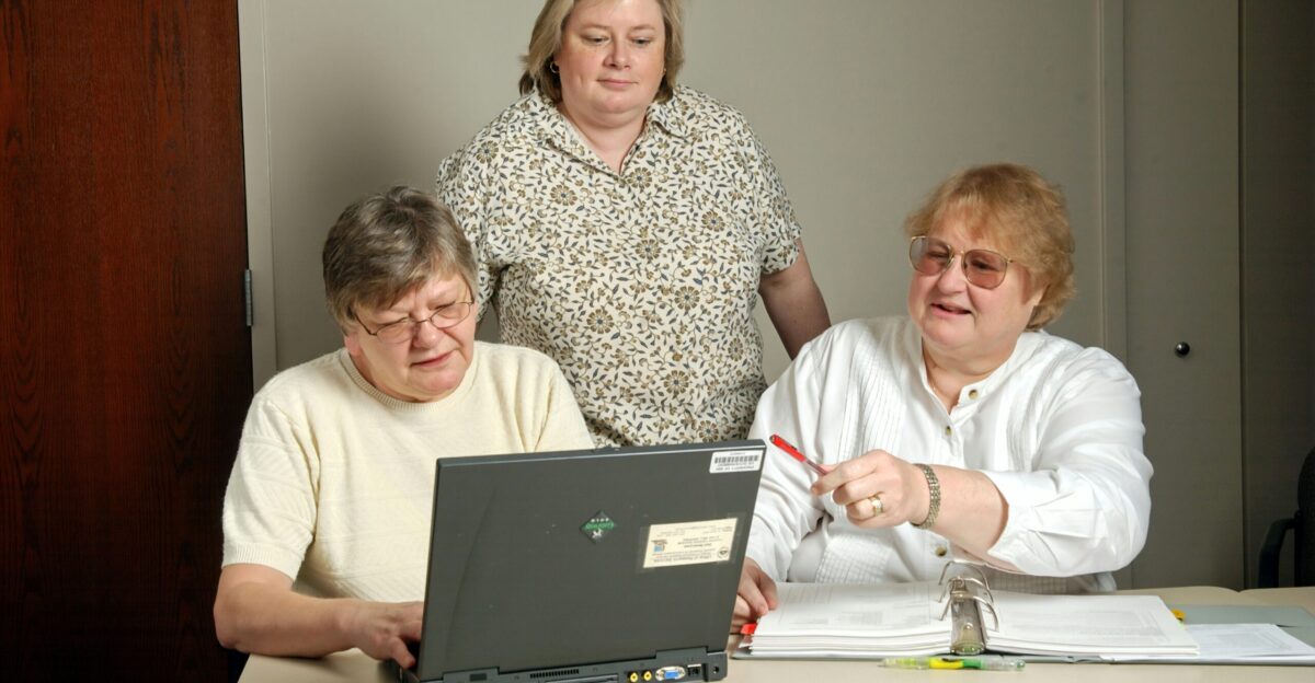 woman in white cardigan sitting beside woman in black and white floral shirt