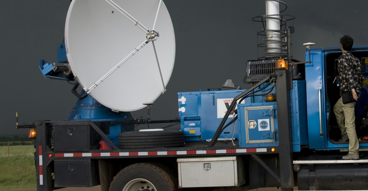 man in blue jacket and blue denim jeans sitting on blue truck