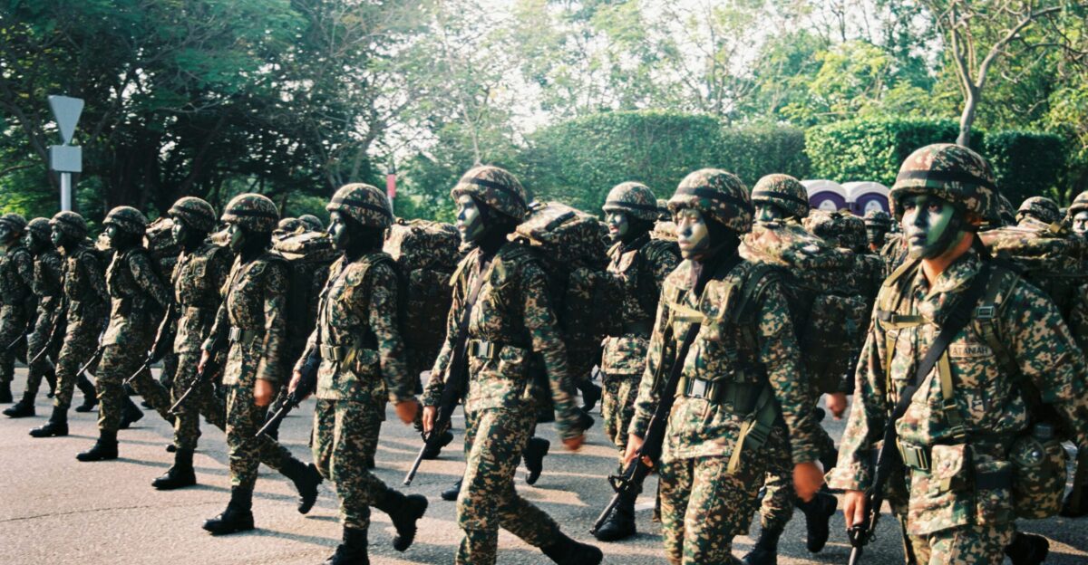 group of men in camouflage uniform standing on road during daytime