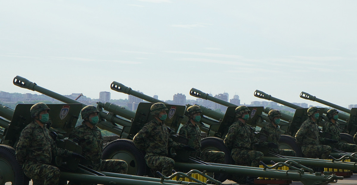 soldiers in green camouflage uniform standing on gray asphalt road during daytime